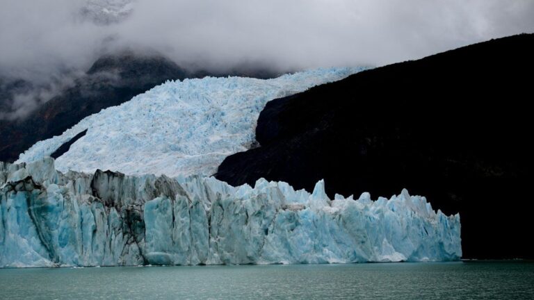 Ilustración de montañas con glaciares y un mapa de Argentina de fondo, representando el debate nacional.