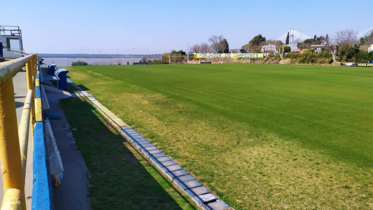 Vista de la entrada del estadio de Rosario Central con niños en el campo de juego