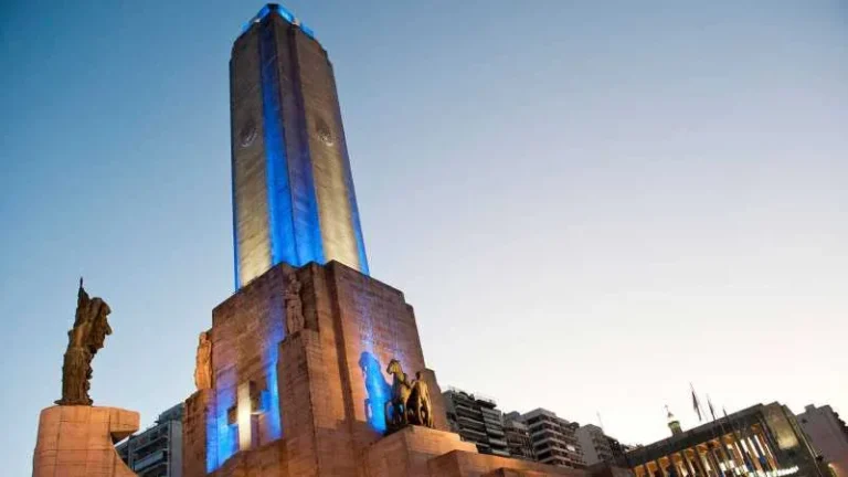 Personas reunidas frente al Monumento Nacional a la Bandera en Rosario, algunas con prendas rojas.